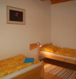 Rekreačný dom Donovaly 2955 - apartmán A: 1 x dvojlôžková izba (1 x  manželská posteľ), 1 x dvojlôžková izba (2 x  samostatné lôžko),  + 2 x prístelka (1 x rozkladací gauč, spoločenská miestnosť  ), spoločenská miestnosť  prepojená s jedálenským kútom (TV, DVD - prehrávač, posedenie), kuchyňa (chladnička s mrazničkou, rýchlovarná kanvica, sklokeramická varná doska, elektrická rúra na pečenie, mikrovlnka), kúpelňa (sprchovací kút, WC v kúpeľni, umývadlo), spoločný vchod s inou izbou alebo apartmánom, prízemie